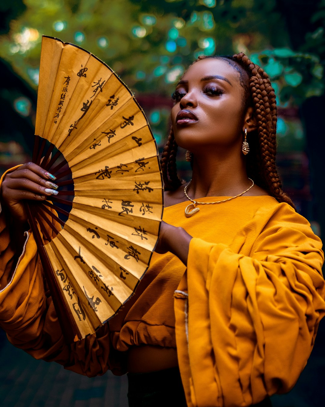 services-02 a-woman-with-braids-holding-a-yellow-fan-kjuc35qbbtm