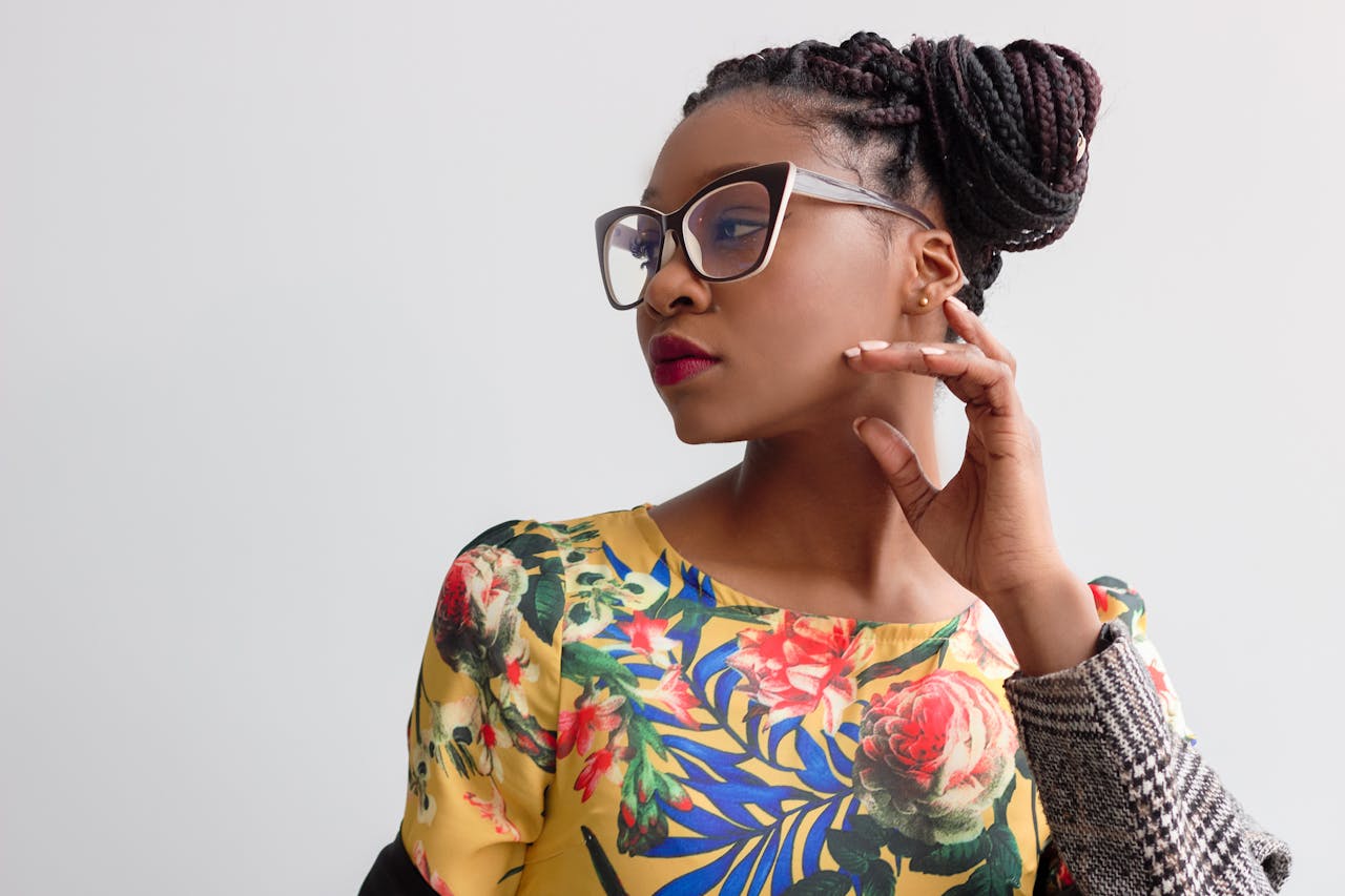 services-04 Elegant portrait featuring a woman in glasses with braided hairstyle and floral top.